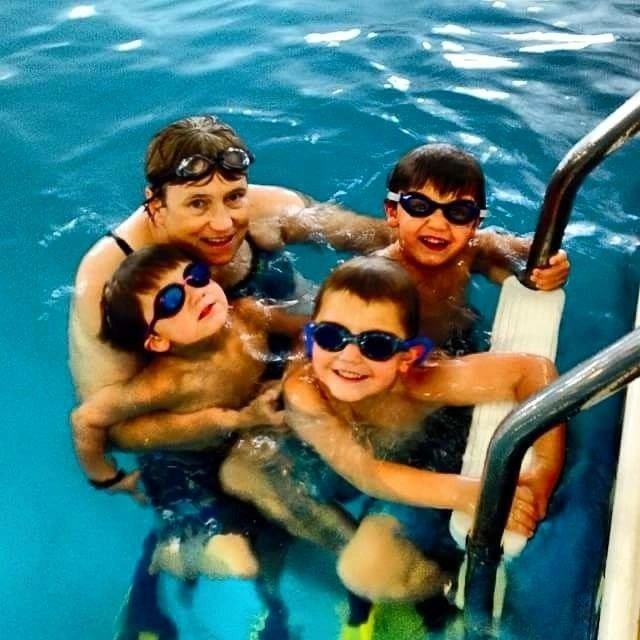 Four children with goggles in the pool
